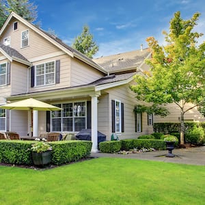 large beige house with large yard space 